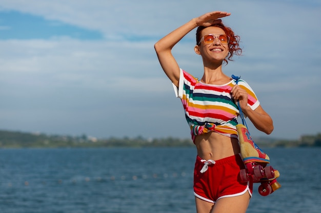 80 年代の美学のローラー スケートでビーチにいる女性のポートレート