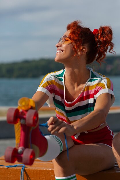 Portrait of woman at the beach with roller skates in 80's aesthetic