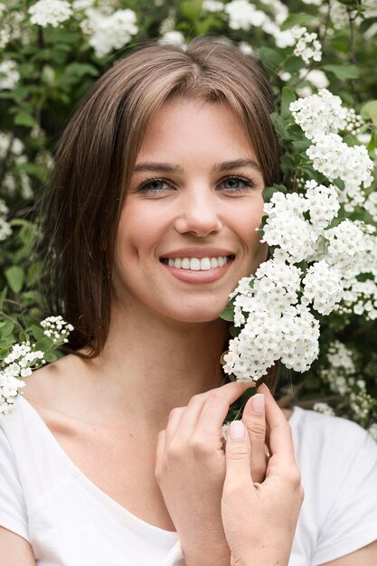 自然の花の横にある肖像画の女性