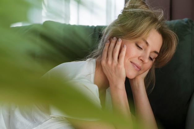 Free photo portrait of a woman and blurred house plant