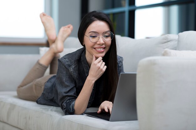 Portrait of woman browsing the laptop on a couch