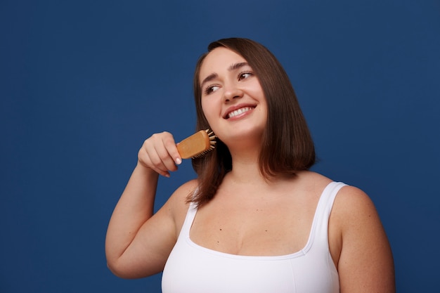 portrait of woman brushing her hair as part of her beauty regimen