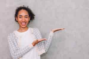 Foto gratuita ritratto di donna d'affari che mostra la mano per presentare qualcosa sullo spazio di copia bellezza nero africano americano isolato su sfondo grigio