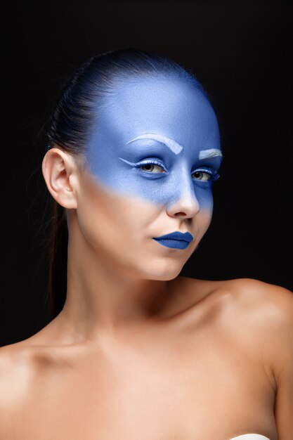 Portrait of a woman covered with blue paint