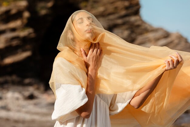 Portrait of woman covering her face with veil at the beach