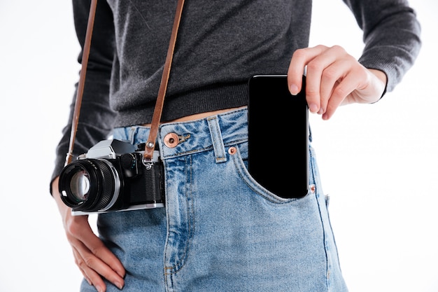 Портрет женщины в джинсовых джинсах с ретро-камерой