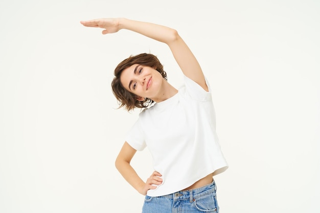 Free photo portrait of woman doing exercise fitness movements bending arm sideways and stretching body standing