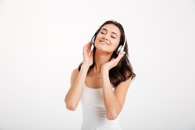 Portrait of a woman dressed in tank-top listening to music