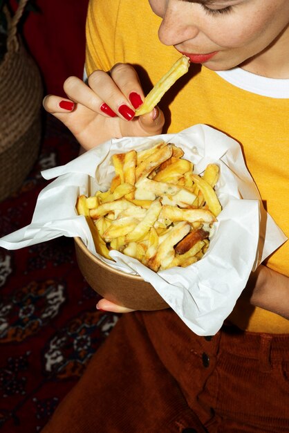 Portrait of woman eating a dish of poutine