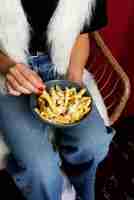 Free photo portrait of woman enjoying a dish of poutine