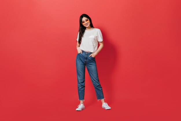 Портрет женщины в полный рост, в белой футболке и джинсах