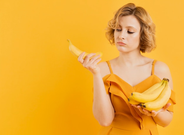 Portrait woman holding bananas