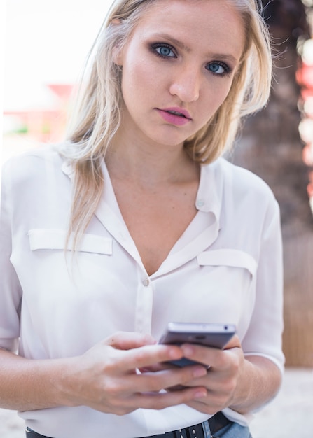 Free photo portrait of a woman holding cellphone