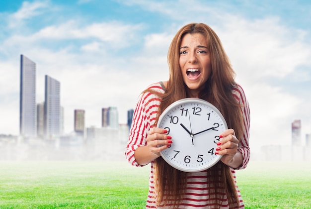 Portrait of woman holding clock and screaming