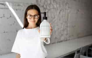 Free photo portrait of woman holding disinfectant