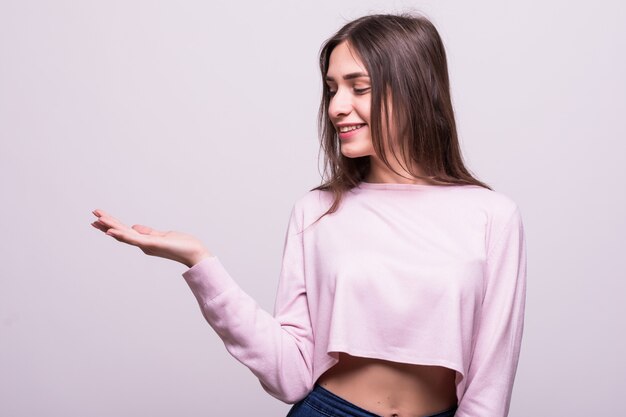 Portrait of woman holding an empty copy space on the open hand palm, over white background