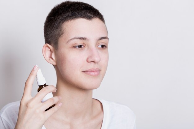 Portrait woman holding face care product