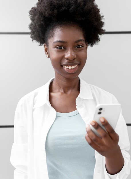 Free photo portrait of woman holding her smartphone