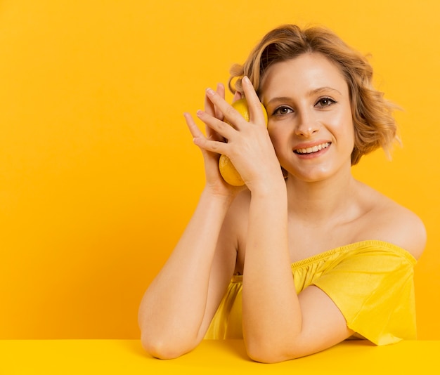 Free photo portrait woman holding lemons