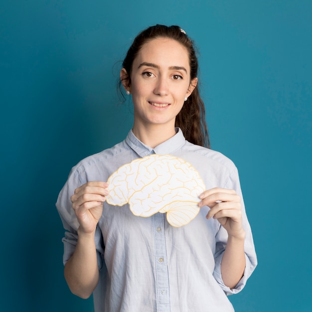 Portrait of woman holding paper brain