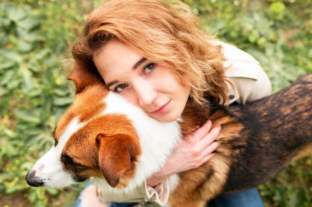 Portrait of woman hugging her dog