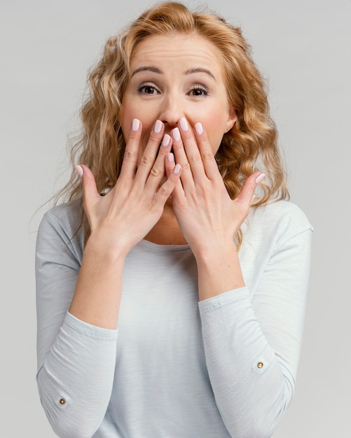 Portrait woman laughing and covering her mouth with hands