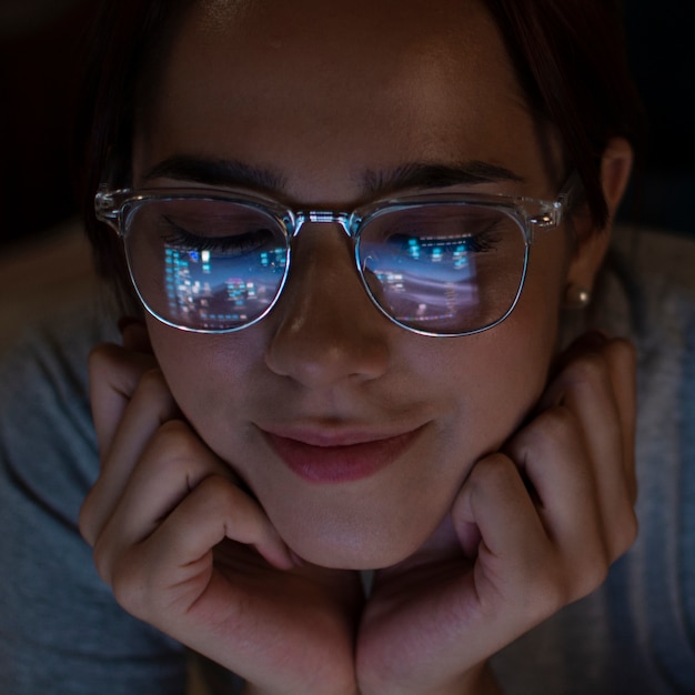 Free photo portrait of woman looking at laptop late at night