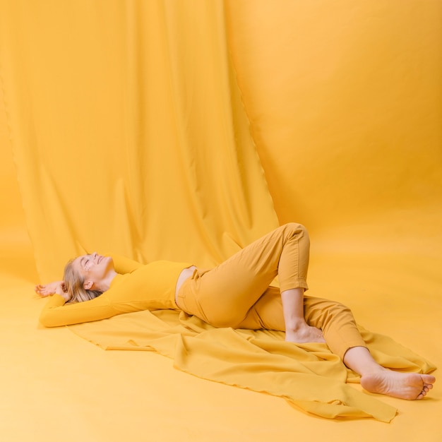 Portrait of woman lying in a yellow scene