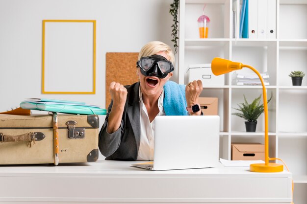 Portrait of woman in office prepared for summer holiday