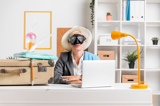 Portrait of woman in office prepared for summer holiday