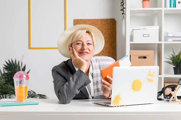 Free photo portrait of woman in office prepared for summer holiday