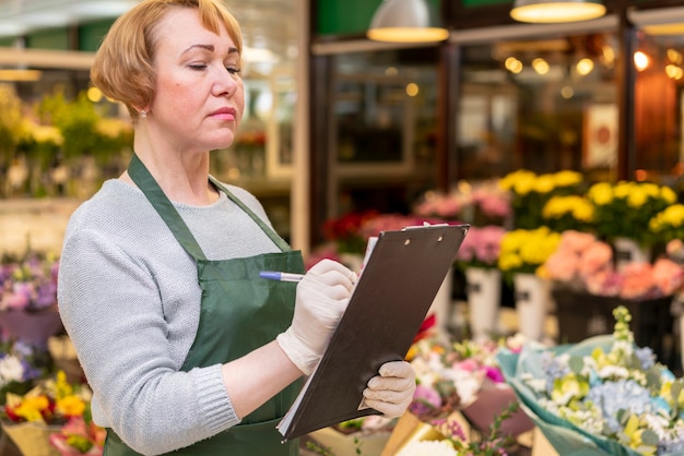 Foto gratuita ritratto dei fiori organizzanti della donna