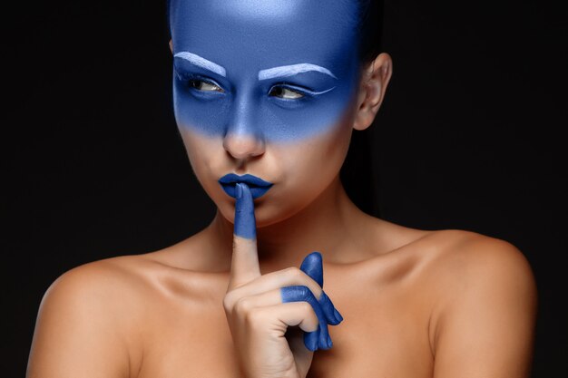 Portrait of a woman posing covered with blue paint