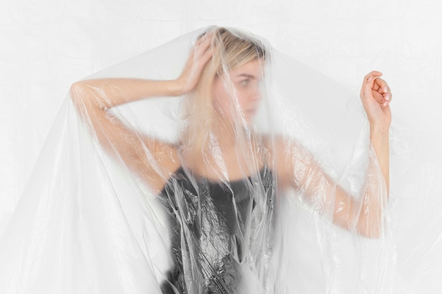 Free photo portrait woman posing with plastic foil