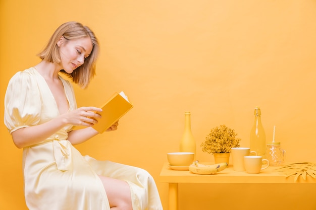 Portrait of woman reading a book in a yellow scene