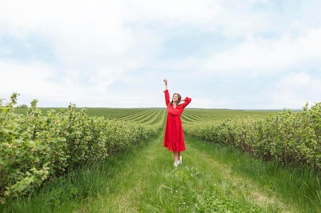 Portrait woman in red dress in field