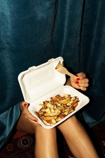 Foto gratuita ritratto di gambe di donna con un piatto di poutine