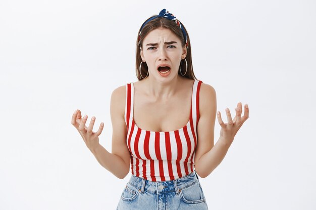 Portrait of woman shaking hands crying and yelling, frowning and whining complaining