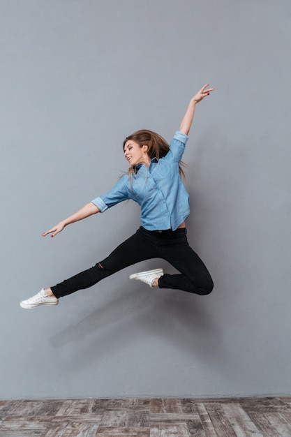 Foto gratuita ritratto di donna in camicia saltando in studio
