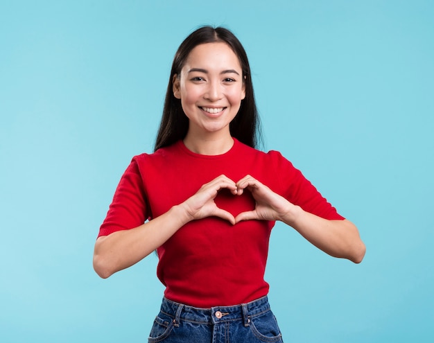 Foto gratuita donna del ritratto che mostra a forma di cuore