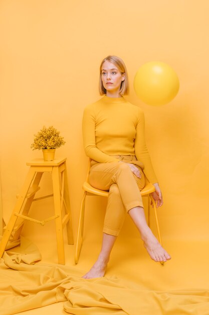 Portrait of woman sitting in a yellow scene