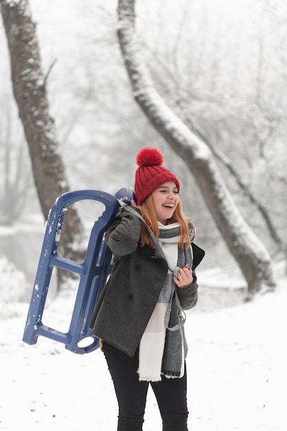 Portrait of woman and sleigh outdoors