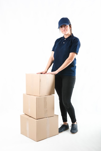 Portrait of a woman standing with stack of cardboard boxes