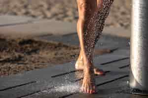 Free photo portrait of woman taking a shower on the beach