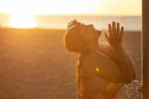 Foto gratuita ritratto di donna che fa la doccia sulla spiaggia