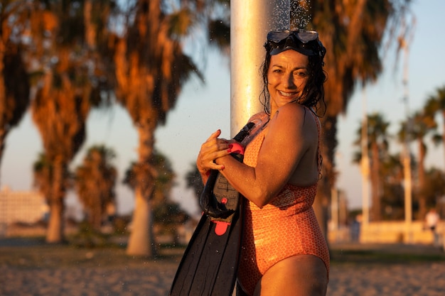 Foto gratuita ritratto di donna che fa la doccia sulla spiaggia