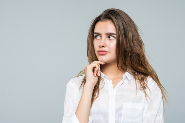 Portrait of woman thinking pensive looking up at copy space. Beautiful young woman on white background