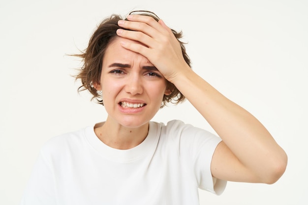 Free photo portrait of woman touches her head looks upset or disappointed forgot something has headache