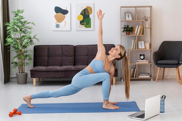 Portrait woman training at home on mat