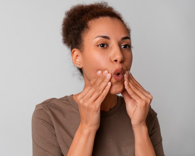 Portrait of woman trying facial yoga massage to stay young